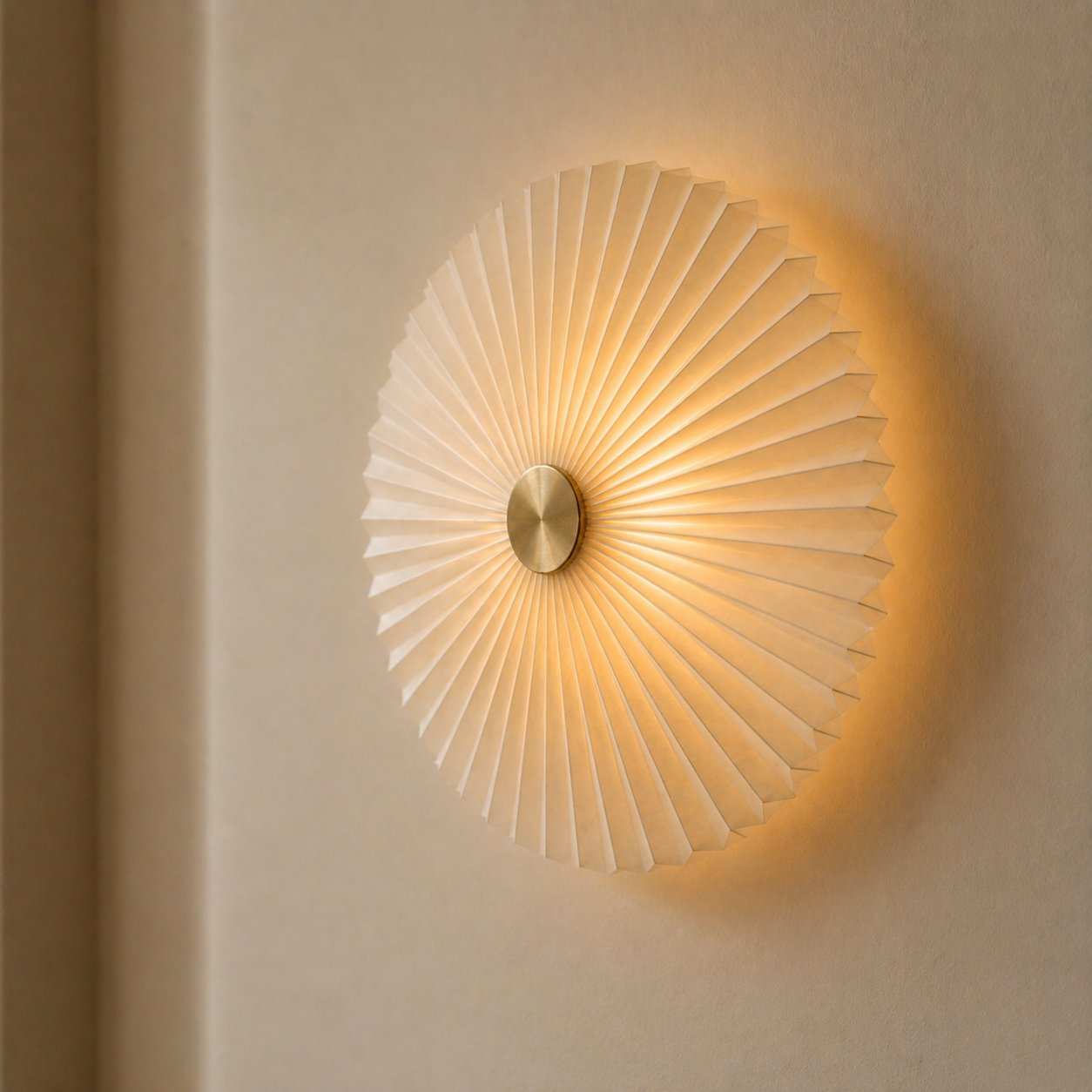 Flat pleated sunburst wall sconce with brass centre, warm glow