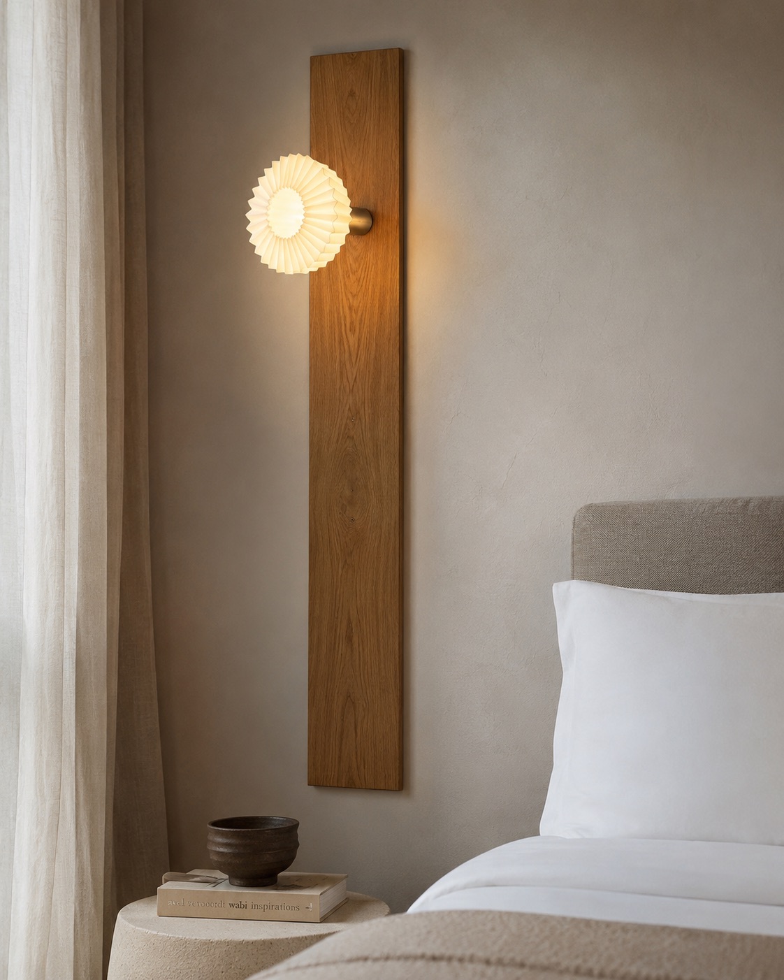 Round pleated ball wall sconce mounted on a tall oak panel