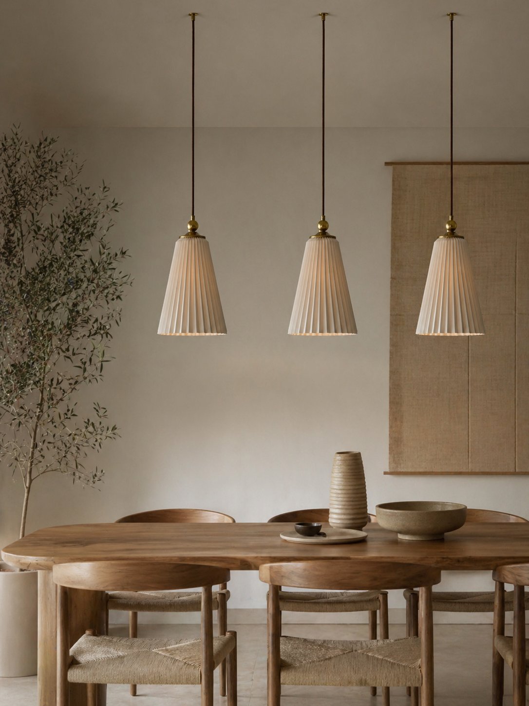 Three pleated pendant lamps above a dining table