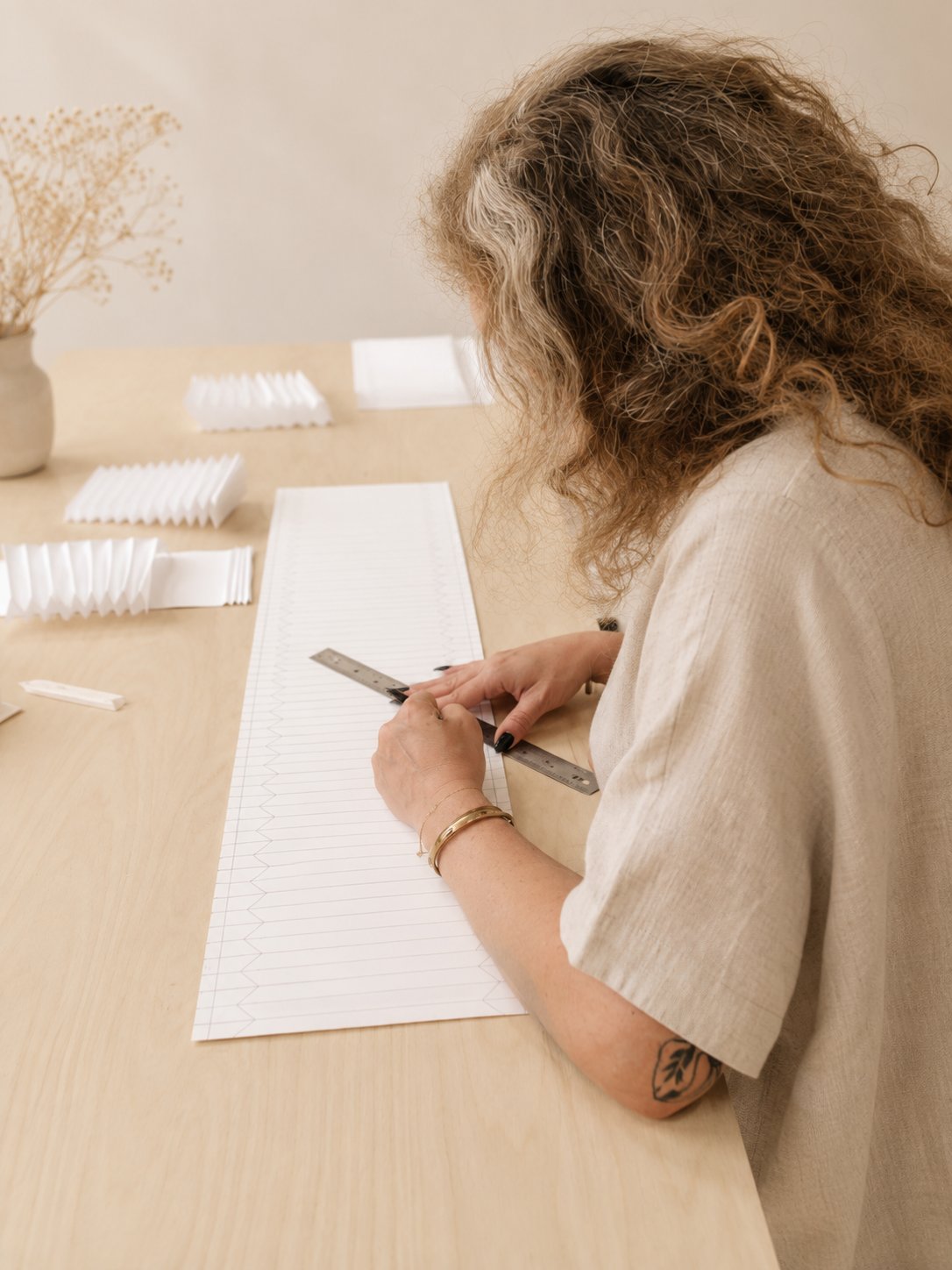 Hand-drafting a pleat pattern on paper